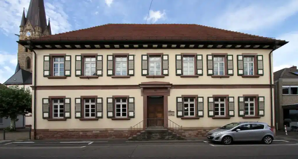Ein historisches zweistöckiges Gebäude mit grünen Fensterläden in Bellheim