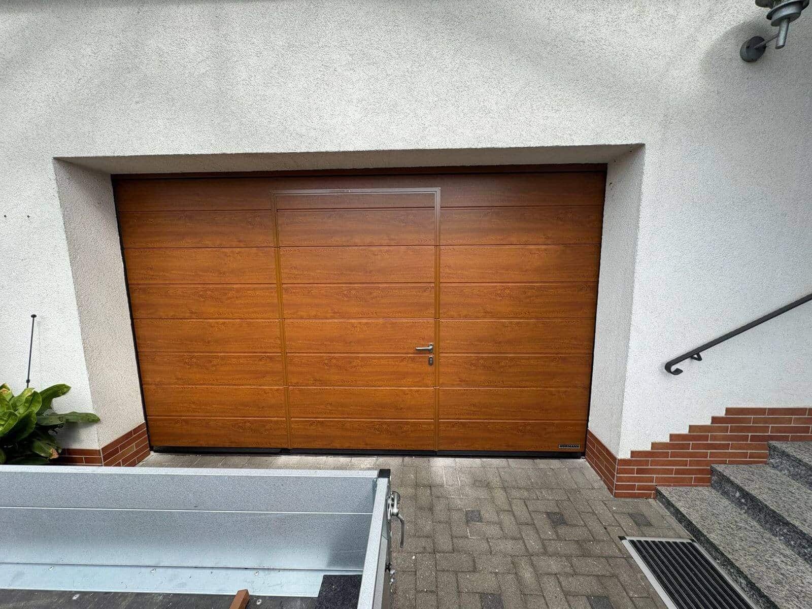 Braunes Garagentor in Holzoptik mit eingebauter Tür