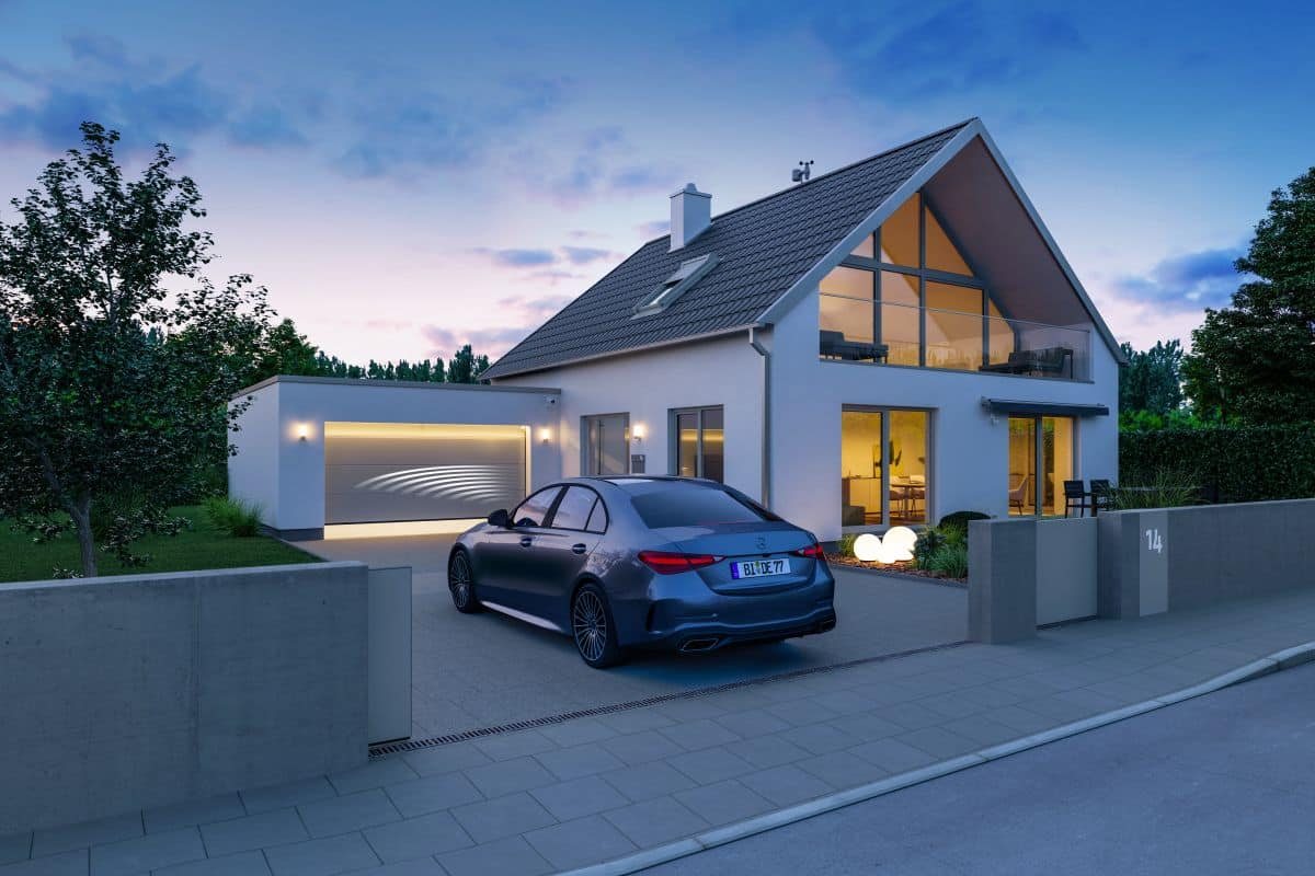 Hörmann Handsender anlernen: Garagentor öffnet sich per Funk an einem modernen Haus.
